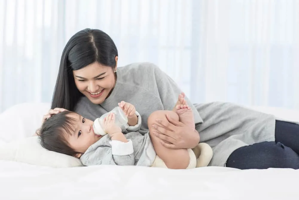 bé tự cầm bình sữa