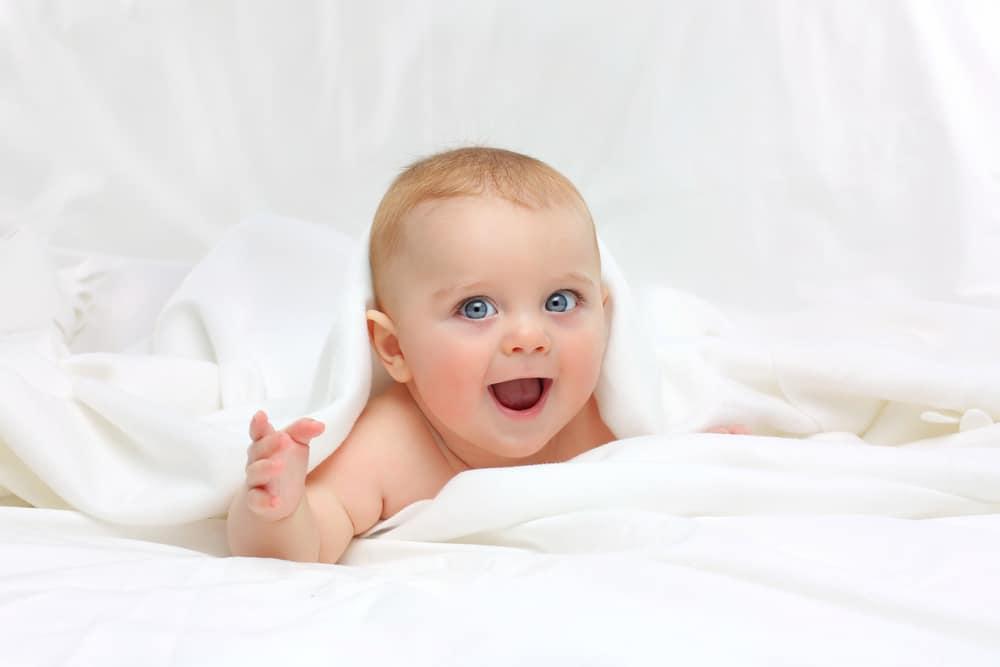 em bé nằm trên giường