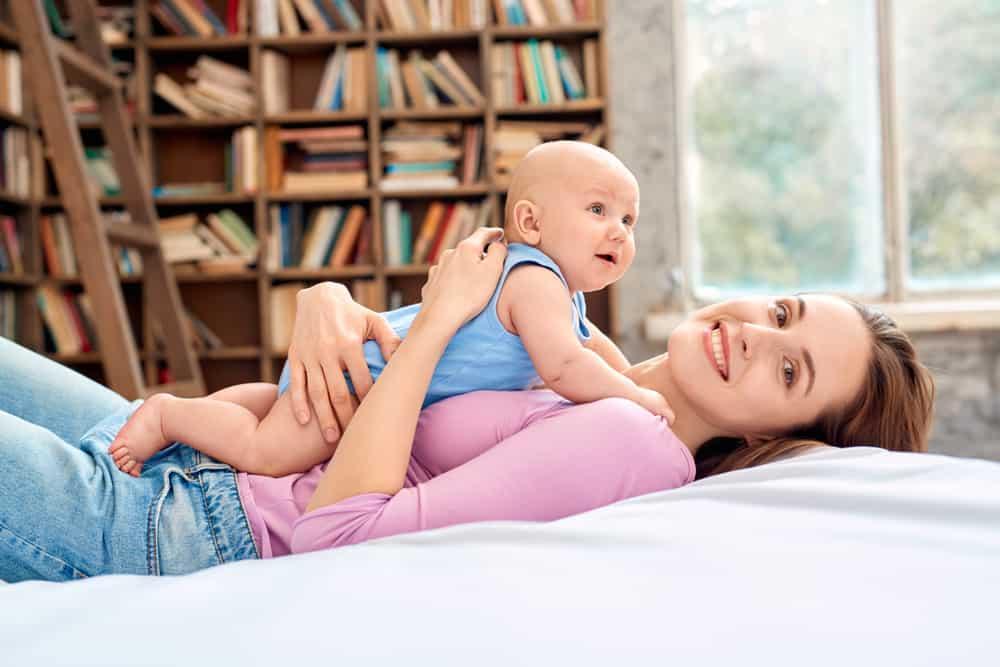 để bé nằm sấp trên ngực mẹ để tập ngóc đầu